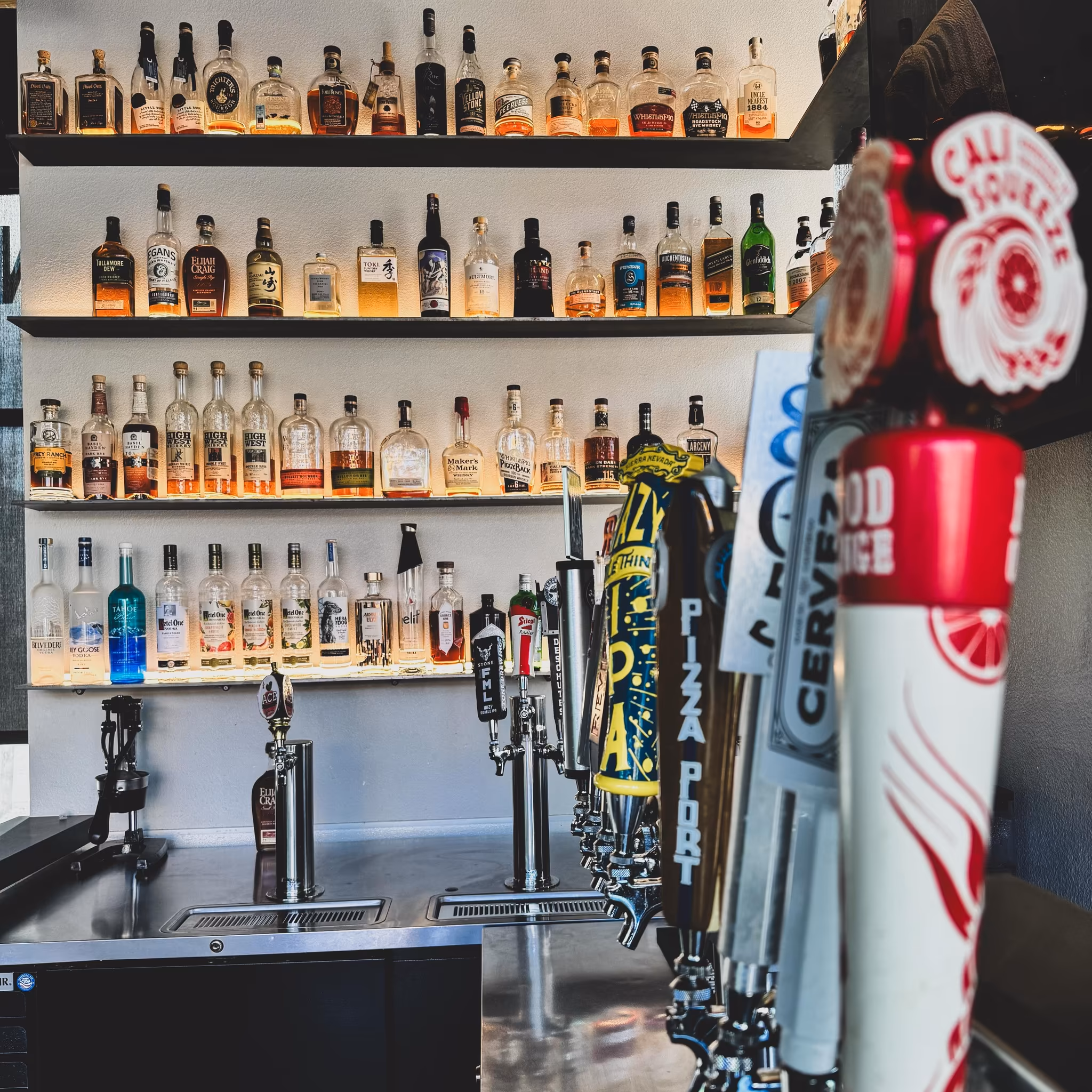 Atlas Landing back bar with whiskey bottles and draft handles