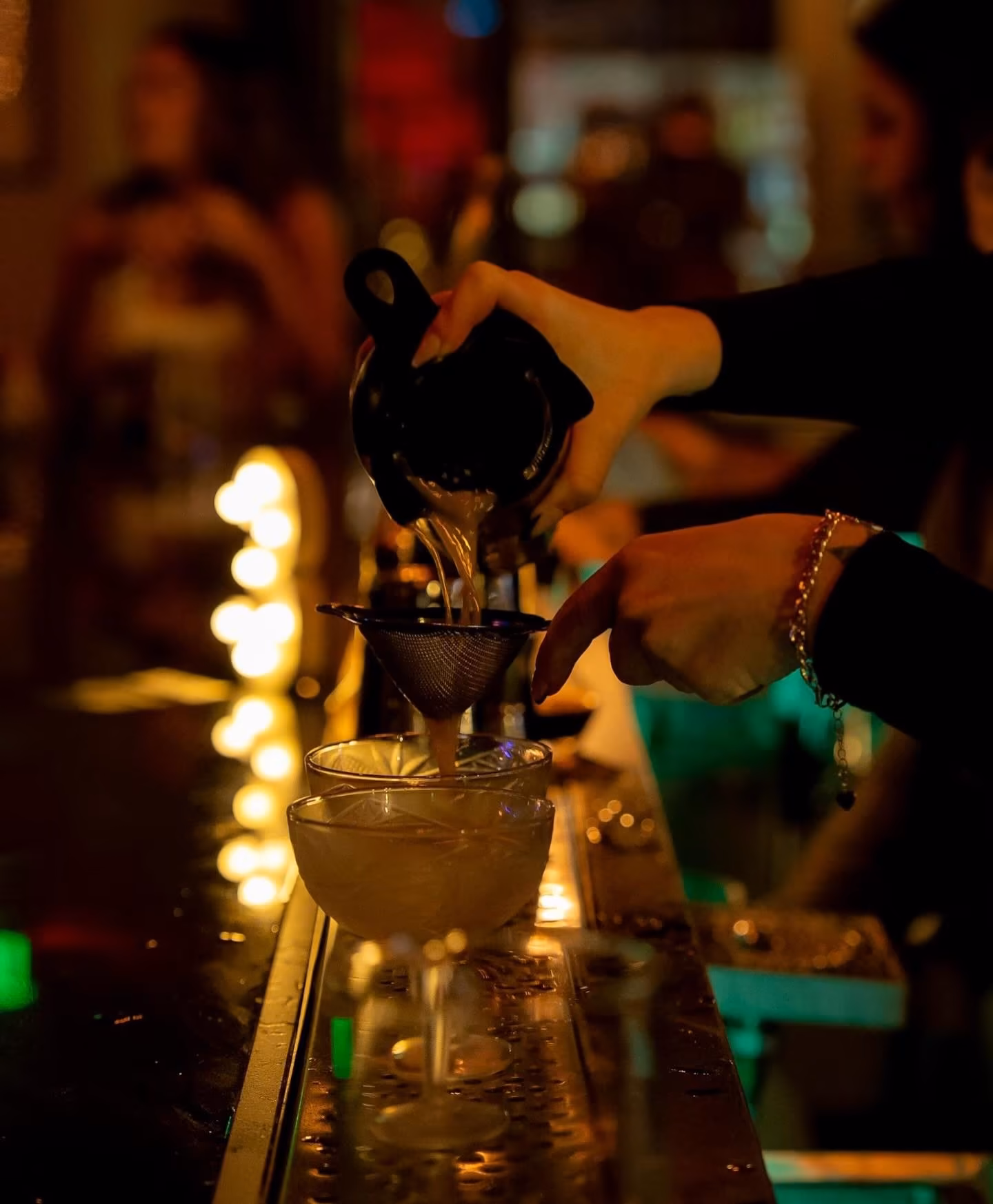 Bartender straining a cocktail at Atlas Landing