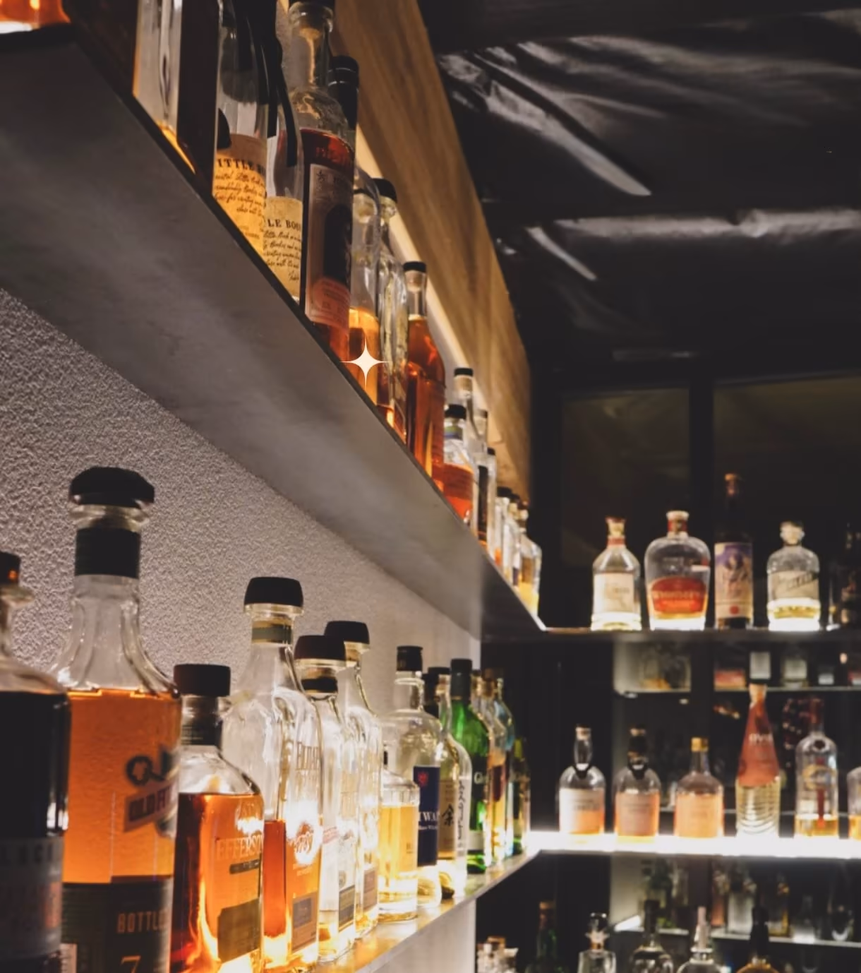 Illuminated whiskey selection inside Atlas Landing