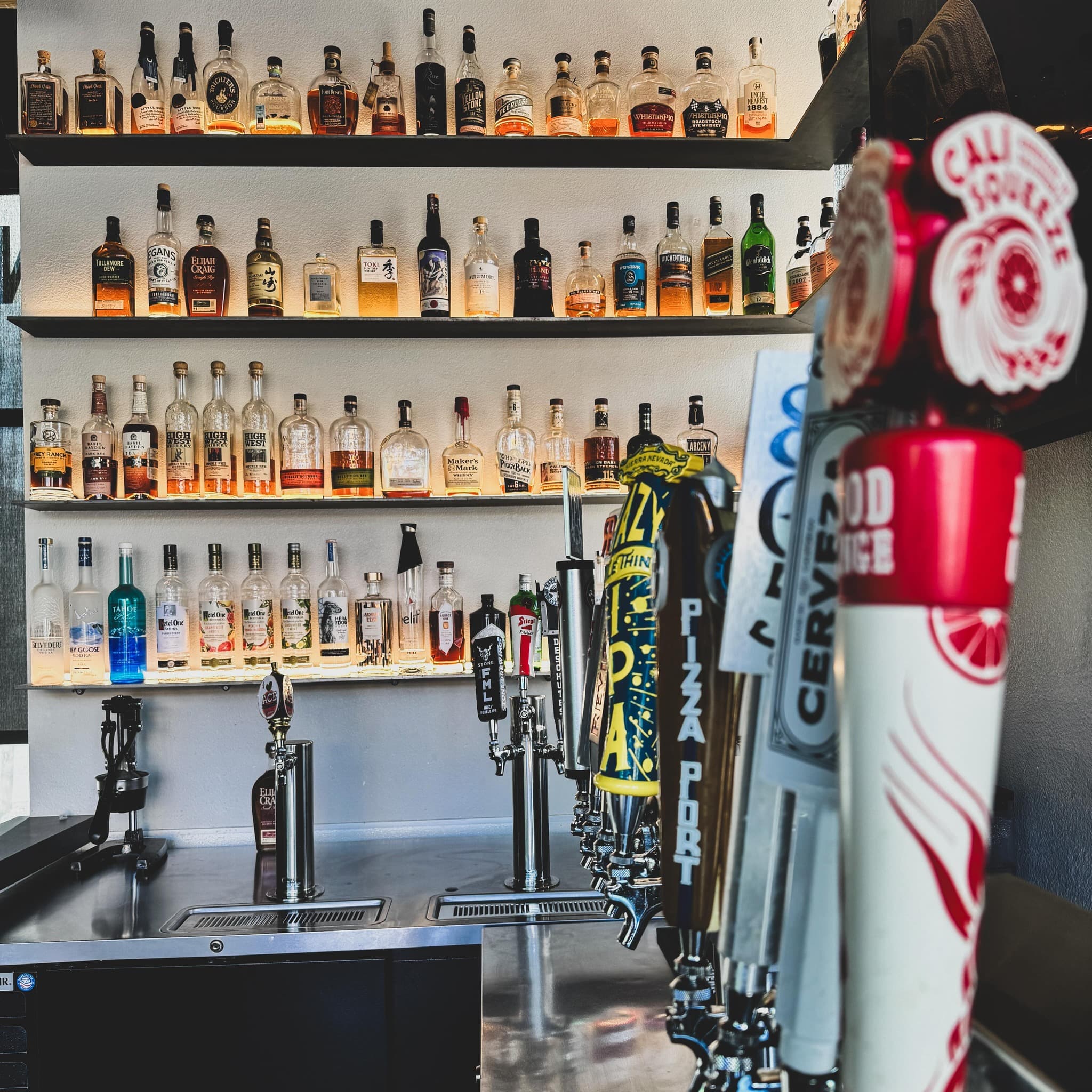 Atlas Landing back bar with whiskey bottles and draft handles