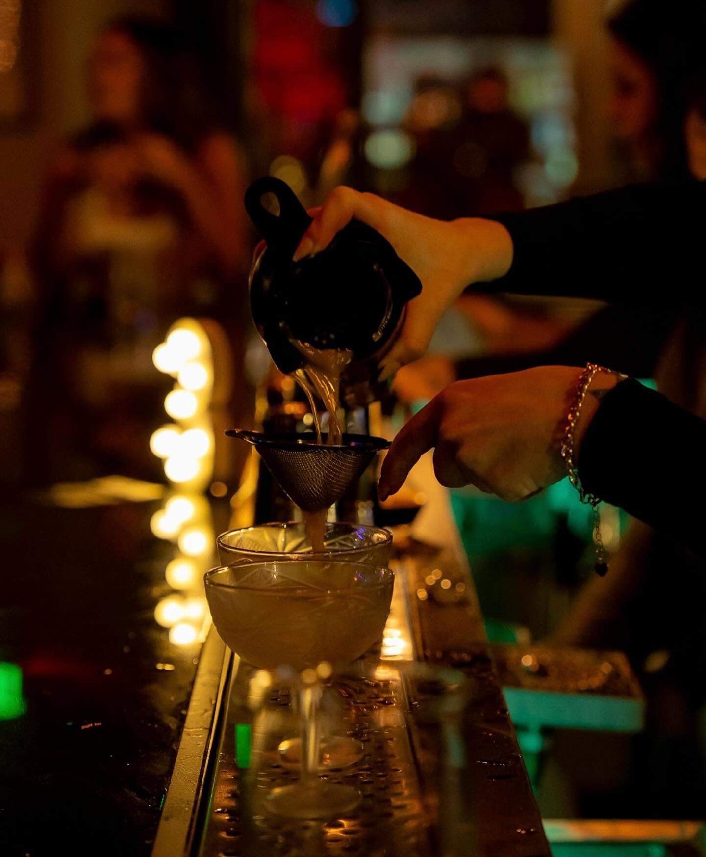 Bartender straining a cocktail at Atlas Landing